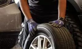 Tire technician inspecting a tire with gloves on